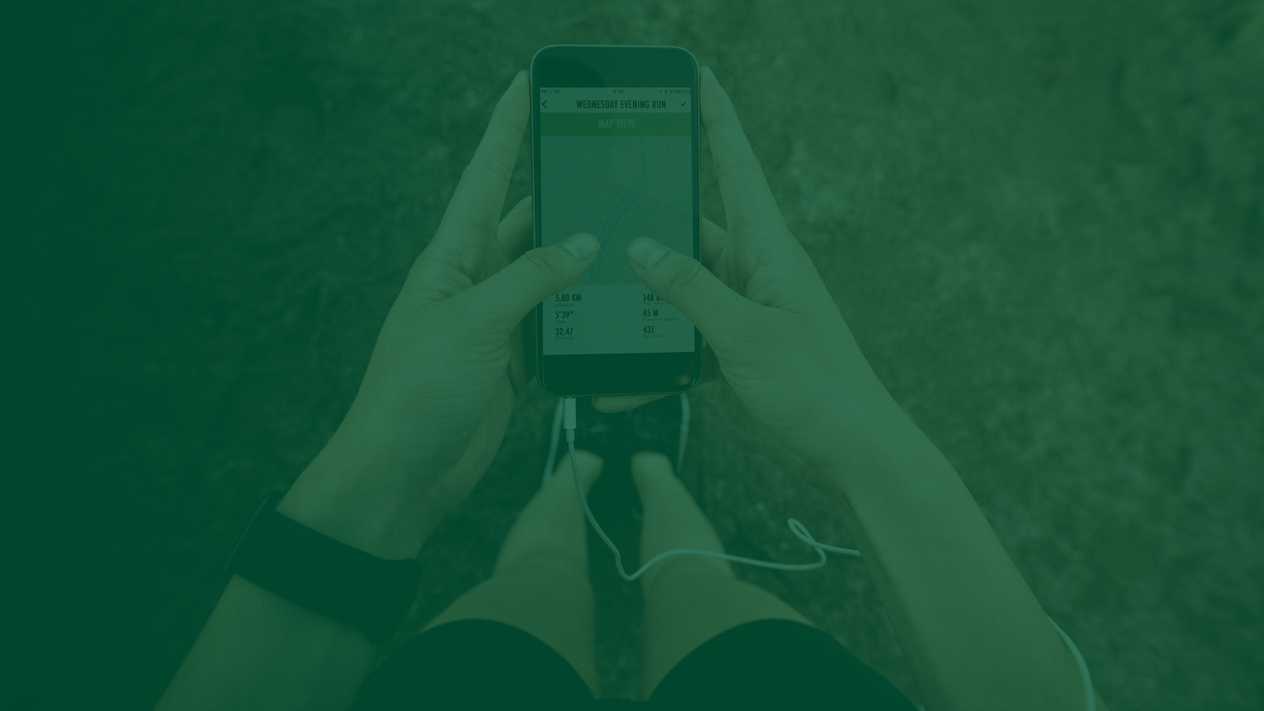 Hands holding a phone showing a fitness app