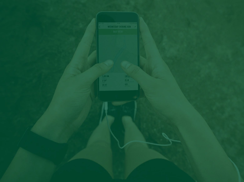 Hands holding a phone showing a fitness app