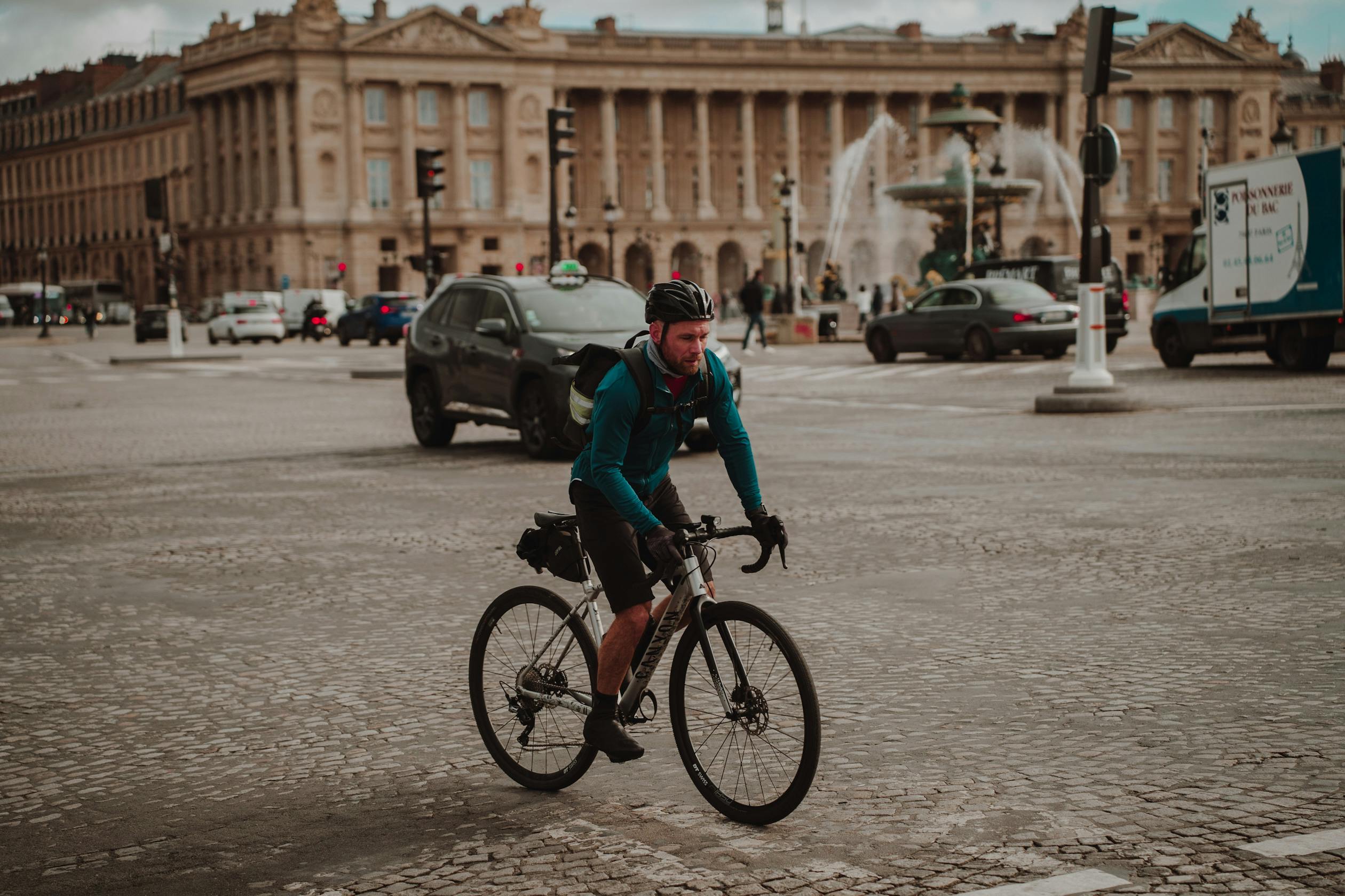 Man Cycling on the Cobblestone Street in Front of the Hotel de Crillon in Paris, France