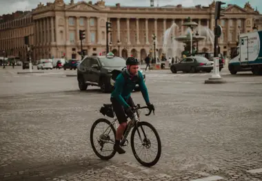 Man Cycling on the Cobblestone Street in Front of the Hotel de Crillon in Paris, France