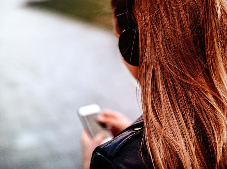 Girl with long hair listening to music on headphones
