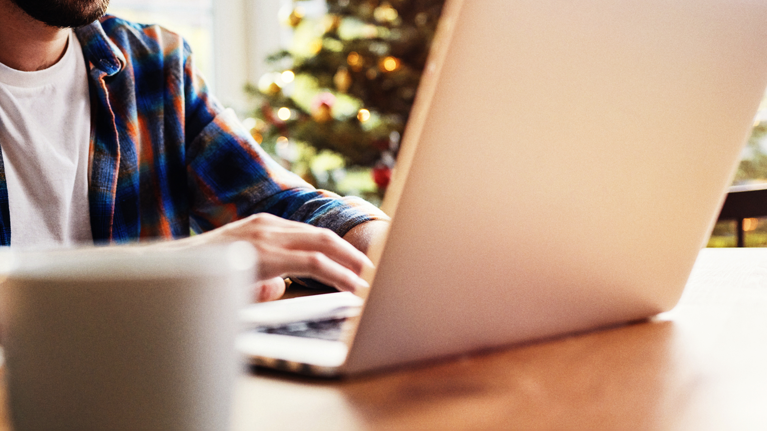 Christmas Tree Man Reporting using a laptop