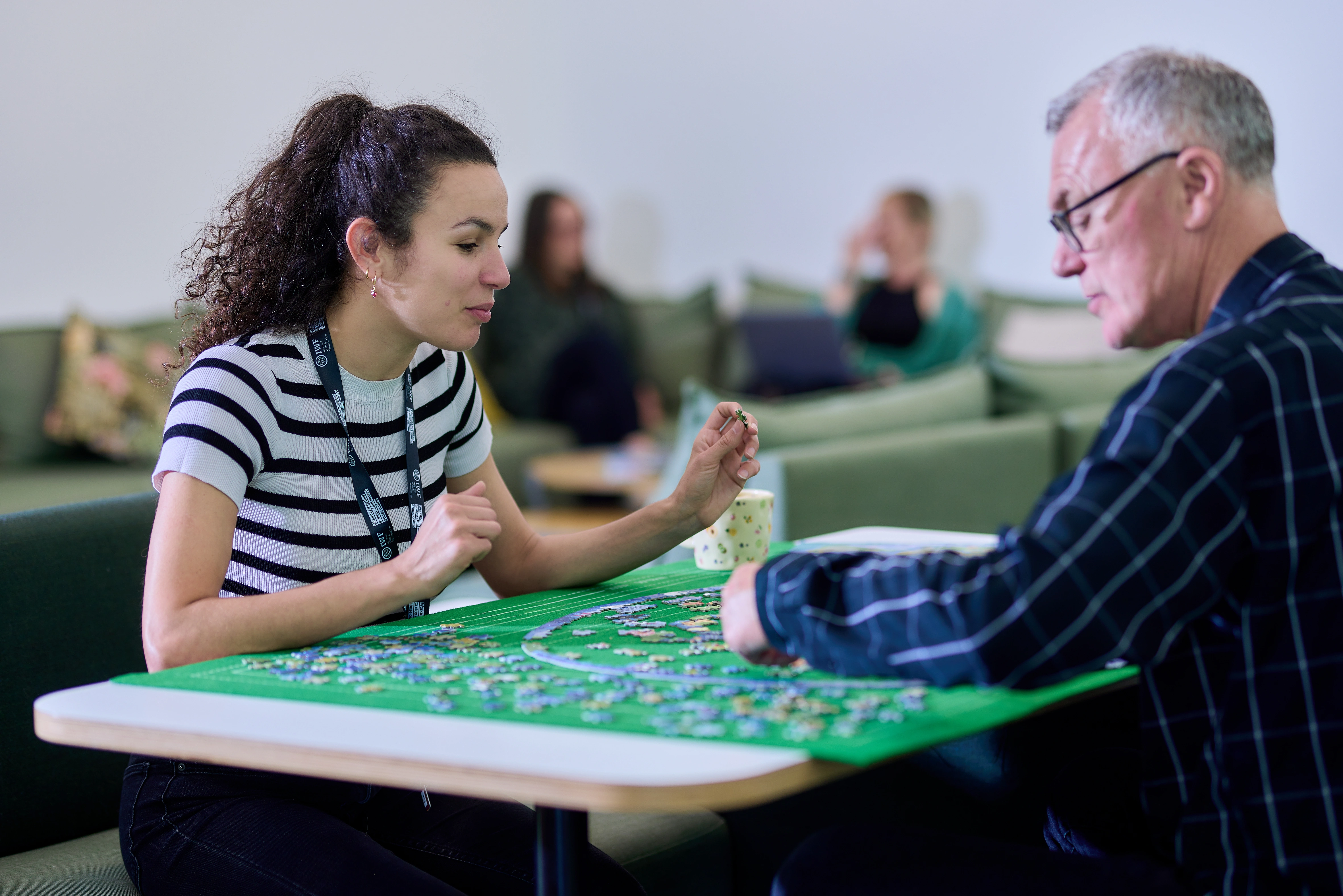 Two team members IWF working on a jigsaw puzzle