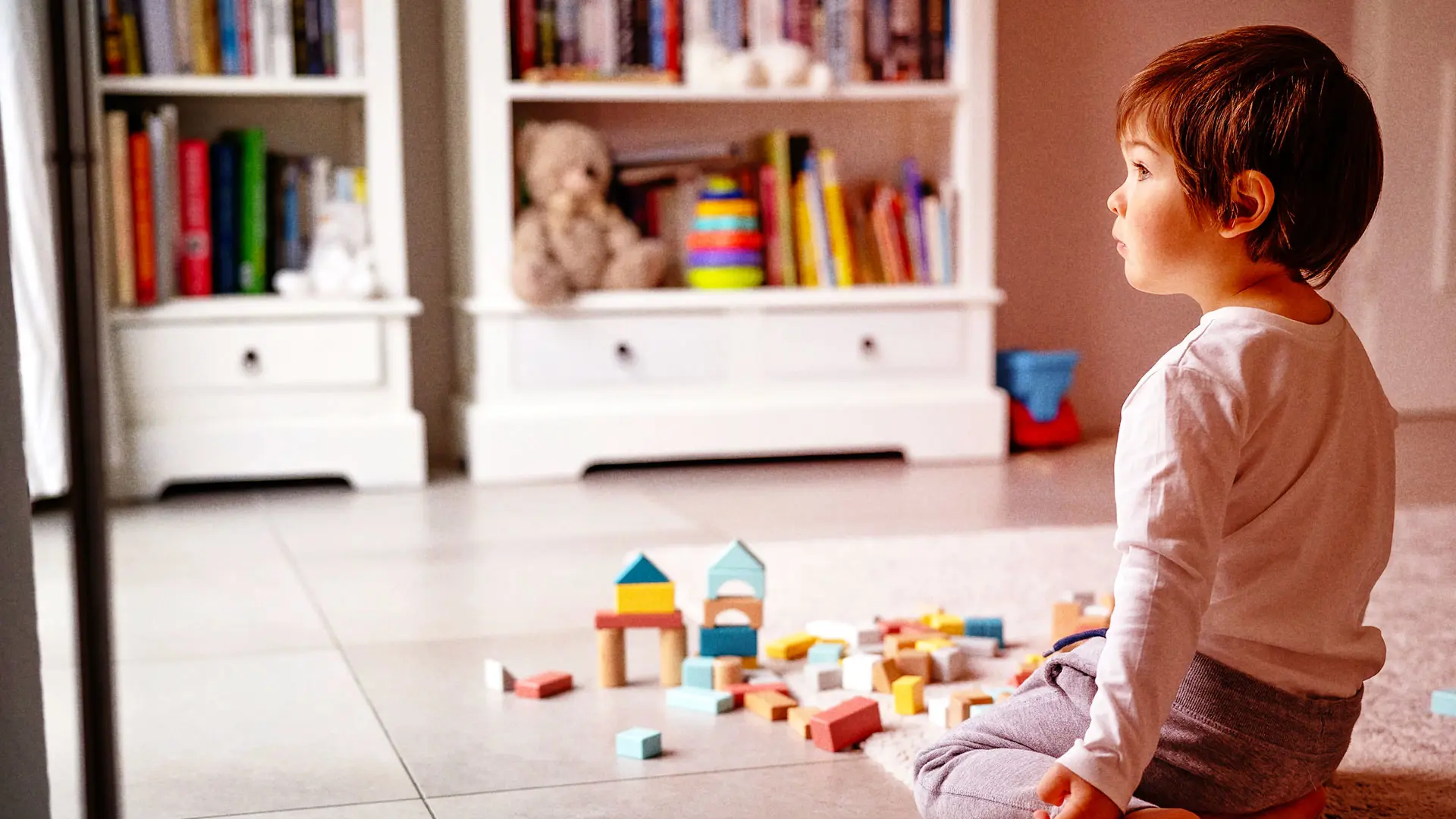 Child in playroom looking at a window