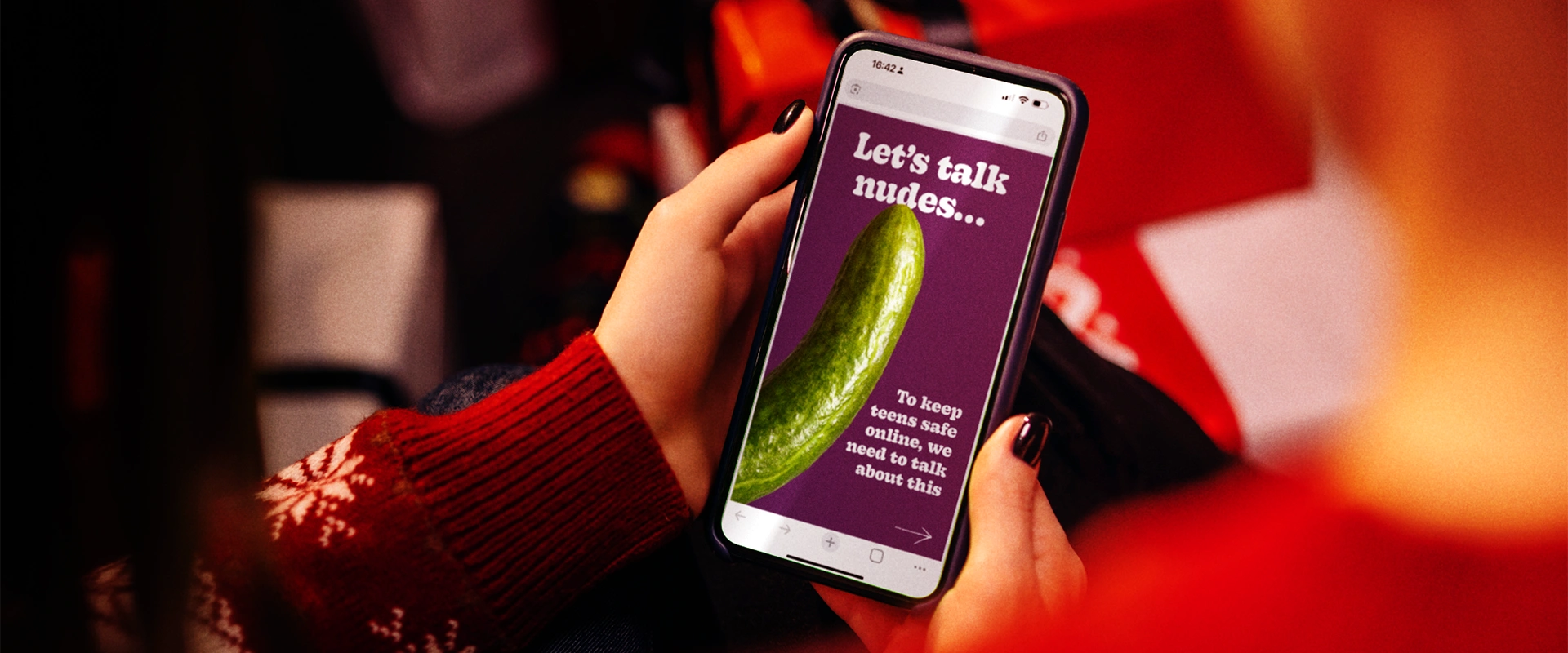 IWF's UK Report Page being accessed via a mobile showing a laptop and keyboard in the background.