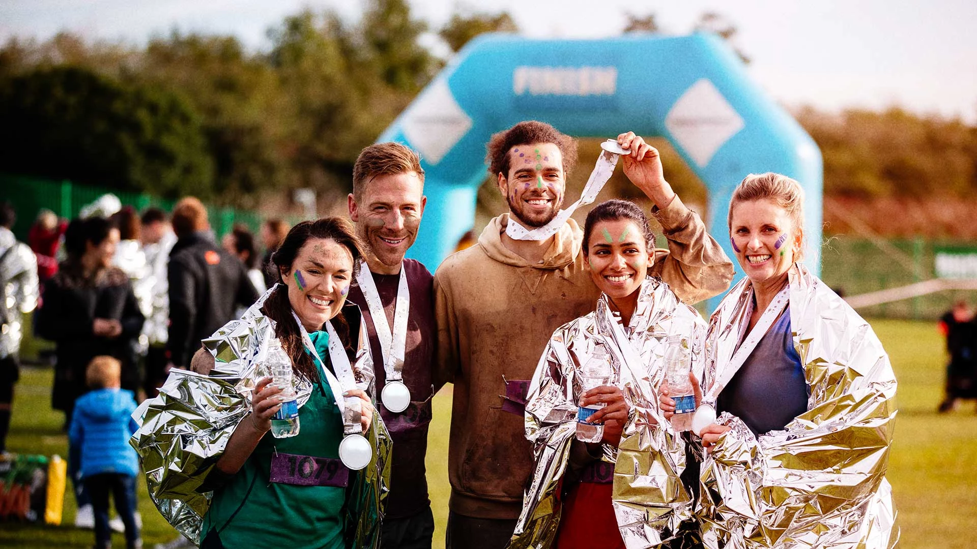 Five people at the end of a marathon with medals