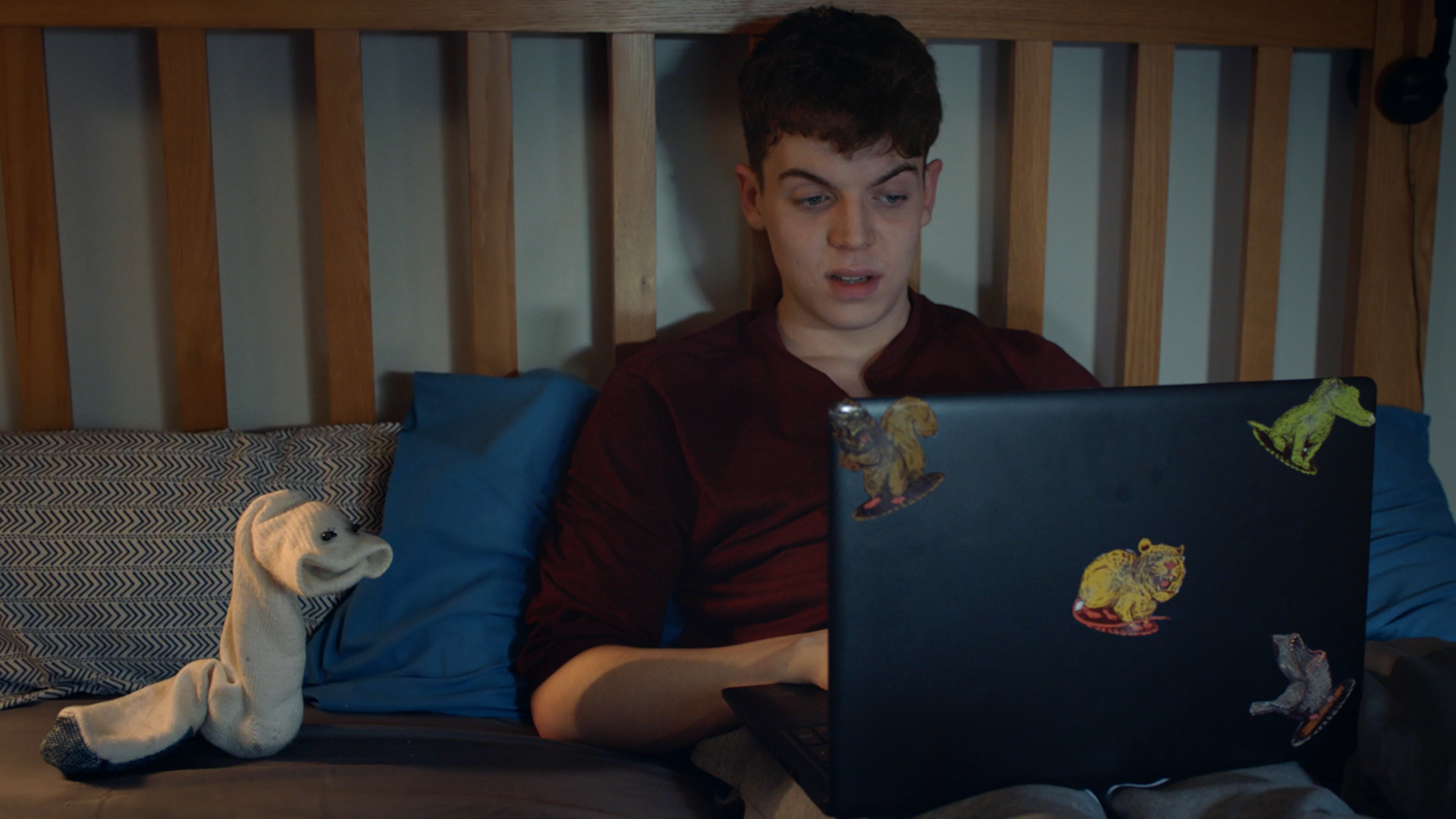 Young man and animated sock looking at laptop