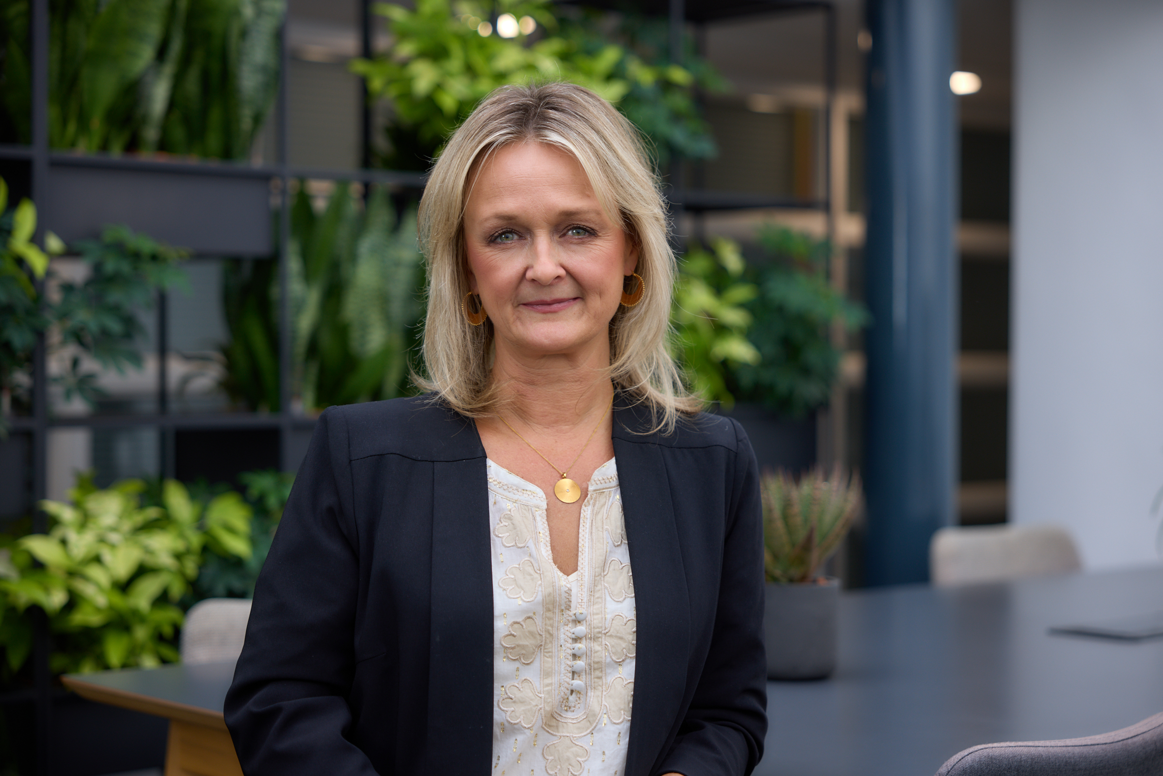 Image of Samantha O'Byrne, IWF Head of People, standing with an array of houseplants in the background. 