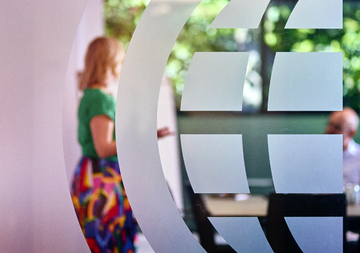 IWF Boardroom window with logo decal, with a meeting taking place with team members