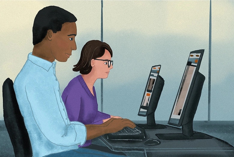 Two people in an office looking at computers